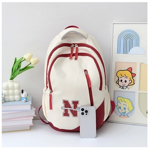 Close-up of large canvas backpack with burgundy accents and spacious compartments