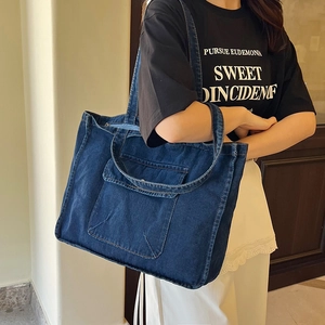 Deep blue denim tote bag with large front pocket and long straps for daily casual use