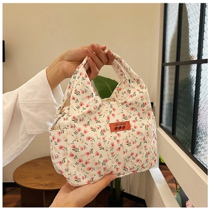 Detail of floral canvas lunch bag with pink tulip patterns and sturdy handles