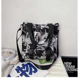 Macro shot of large black and white graffiti canvas bag with nylon handles and buckle details