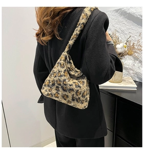 Sac hobo tendance en peluche léopard porté par un mannequin sur un blazer noir chic
