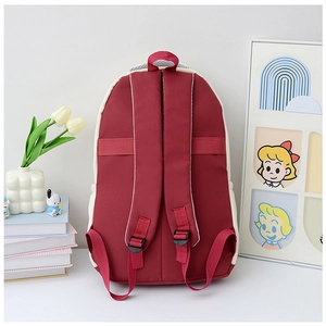Detail view of burgundy and white travel backpack back with padded straps and luggage strap