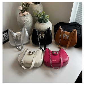 Close-up of crescent underarm bags in multiple colors with metal bow buckles