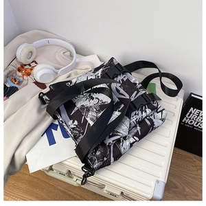Detail of graffiti Oxford cloth messenger bag with adjustable strap on a suitcase