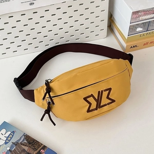 Detail view of bright yellow crossbody bag with brown embroidery logo and adjustable strap