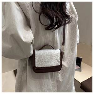Detail of brown leather and white shearling flap on a stylish women's crossbody bag