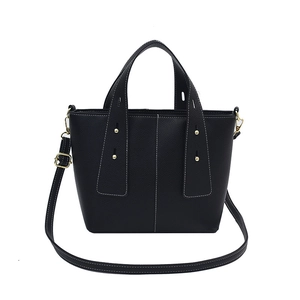 Minimalist black bucket handbag in lychee leather with white contrast stitching and gold hardware