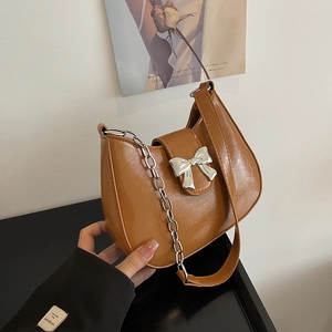 Brown faux leather shoulder bag featuring a silver bow buckle and elegant metal chain strap