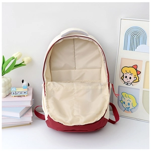 Detail view of the spacious inner compartment and interior pocket of the red and white backpack
