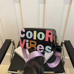 Borsa a tracolla nera con toppe colorate e ampia tracolla viola, design alla moda casuale