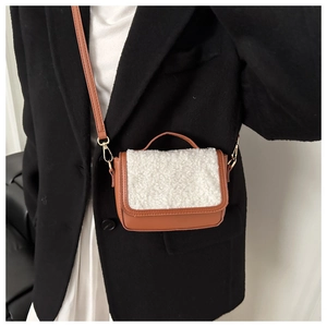 Detail of mini crossbody bag in brown faux leather with white faux fur flap and slim strap