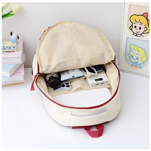 Detail view showing large interior capacity of beige travel backpack with various items