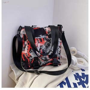 Detail of street-style graffiti pattern and plastic buckles on large oxford tote bag