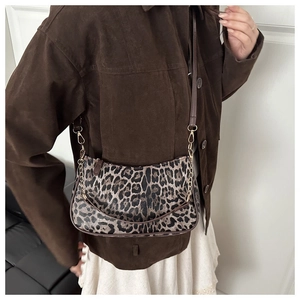 Close-up of leopard print shoulder bag with gold chain and adjustable leather strap