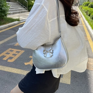 Silver metallic shoulder bag with metal bow detail and slim strap for stylish women