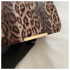 Gros plan du sac à bandoulière léopard avec détails dorés et texture de cuir gaufré