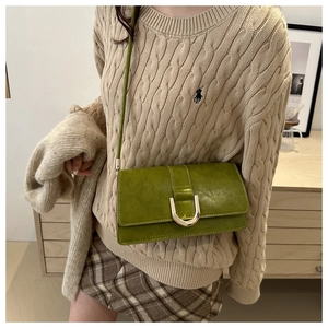Détail du sac bandoulière vert citron avec boucle en U dorée et fermoir magnétique