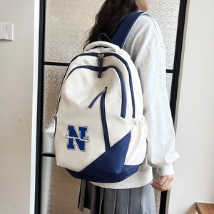 Large capacity canvas travel backpack with blue letter N in white and navy contrast