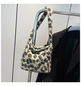 Gros plan du sac hobo en peluche à motif léopard vert et blanc sur un cintre