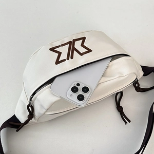 Detailed close-up of white canvas chest bag showing front pocket capacity for a smartphone