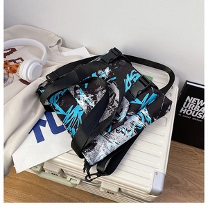 Detail of trendy graffiti oxford tote bag with wide nylon strap and buckle on luggage
