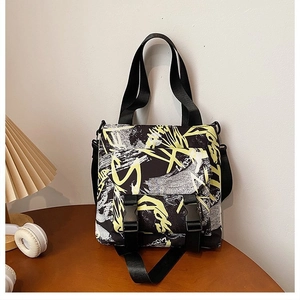 Detail of street graffiti pattern on canvas tote bag with plastic buckles and long straps