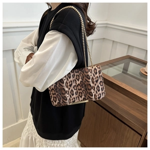 Gros plan du sac léopard avec bandoulière en chaîne dorée et finitions métalliques