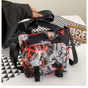 Detail of trendy graffiti oxford bag featuring plastic buckle closure and nylon strap