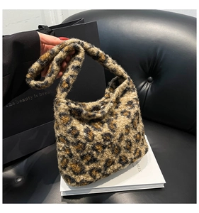 Détail d'un sac à main en peluche léopard avec texture douce sur canapé en cuir