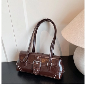 Macro shot of dark brown glossy leather texture with silver buckle on baguette bag