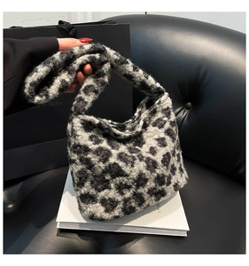 Gros plan du sac seau en peluche à motif léopard avec texture douce sur un livre blanc