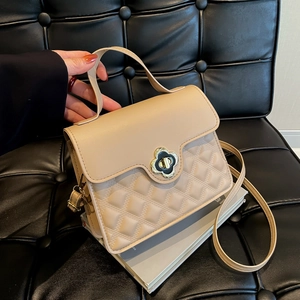 Chic beige quilted crossbody bag with gold clover clasp and top handle for women