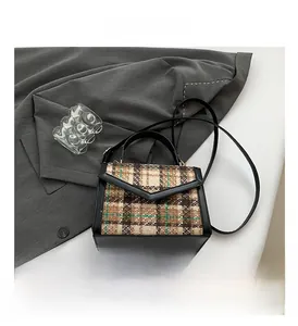 Détail du sac à carreaux en tweed vintage avec garniture en cuir et métal doré