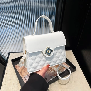 Chic white quilted leather handbag with gold clover lock and adjustable shoulder strap