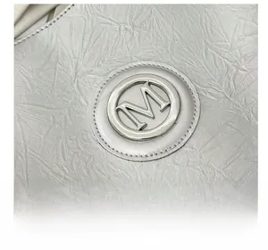 Gros plan sur un sac cabas argenté avec texture plissée et logo métallique M