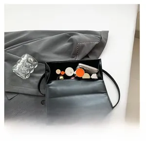 Vue intérieure d'un sac à bandoulière à carreaux noirs avec espace pour téléphone et maquillage
