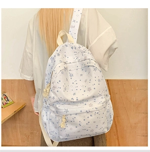 Detail showing high-capacity backpack with blue star patterns and side pockets on model