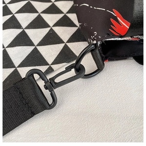 Detail of durable matte black metal buckle and nylon strap on contrast Oxford tote bag
