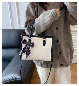 Détail du cabas blanc à texture crocodile avec anses noires et foulard en soie à cœurs