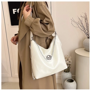 Détail du sac cabas blanc brillant avec logo M argenté et bandoulière chaîne épaisse