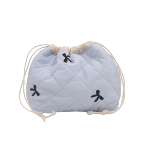 Light blue quilted bucket bag with black bow embroidery and cream drawstring closure