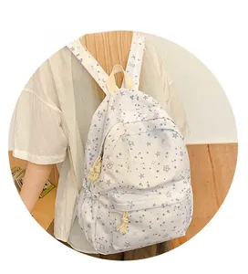 Detail of white canvas backpack with blue star patterns and rope knot zipper puller