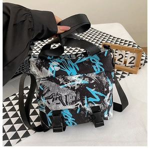 Detail of street graffiti style canvas bag with blue and white abstract print and buckles