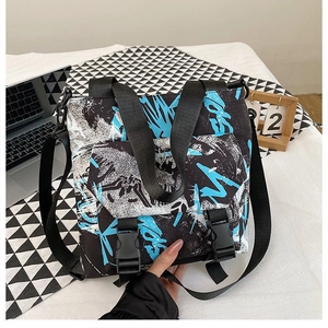 Close-up of contrast color oxford cloth messenger bag with graffiti print and dual buckles