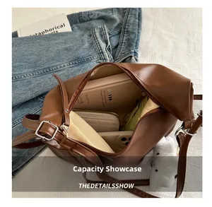 Top view of spacious brown leather tote bag interior with umbrella, wallet and phone
