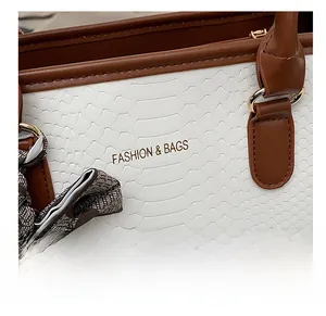 Détails de la texture du cuir blanc gaufré et des ferrures dorées du sac à main