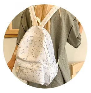 Detailed view of white backpack with blue and grey star patterns and durable straps