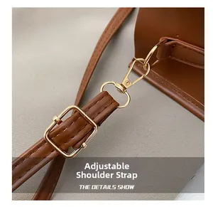 Détail de la bandoulière réglable en cuir marron avec boucle en métal doré