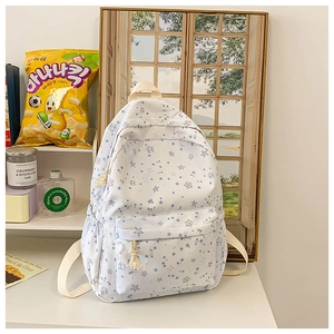 Detail of white backpack with blue star patterns and adjustable cream wide shoulder straps
