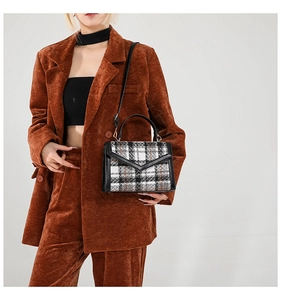 Détail du sac à main rétro en tweed à carreaux avec bordure en cuir sur mannequin